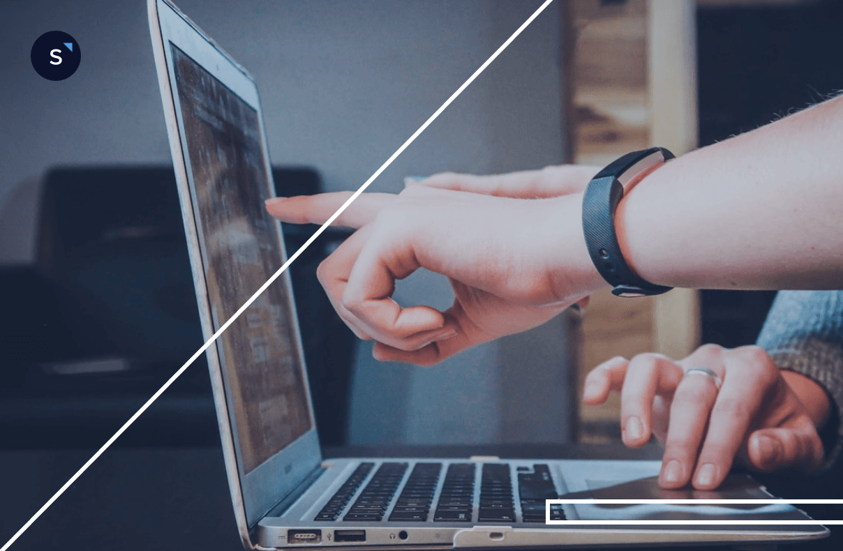 Hands pointing at UTM code tracking data on a laptop screen during a marketing analysis